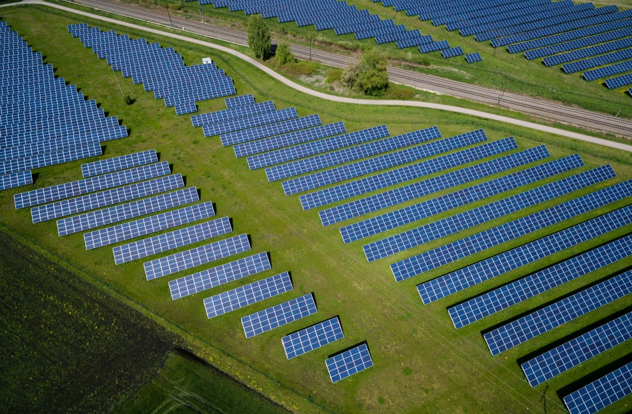 aerial photography of grass field with blue solar panels